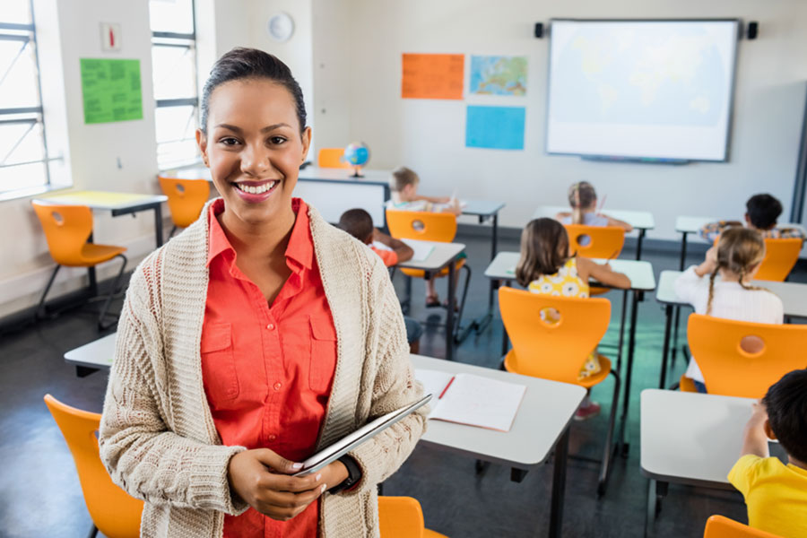 Woman teacher in classroom with students working at their desks